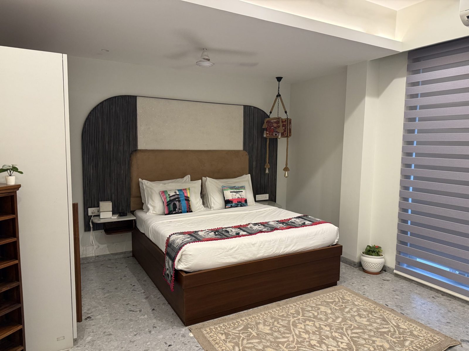 Quarto com cama de casal arrumada com almofadas