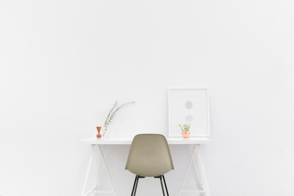 Parede branca com mesa e cadeira