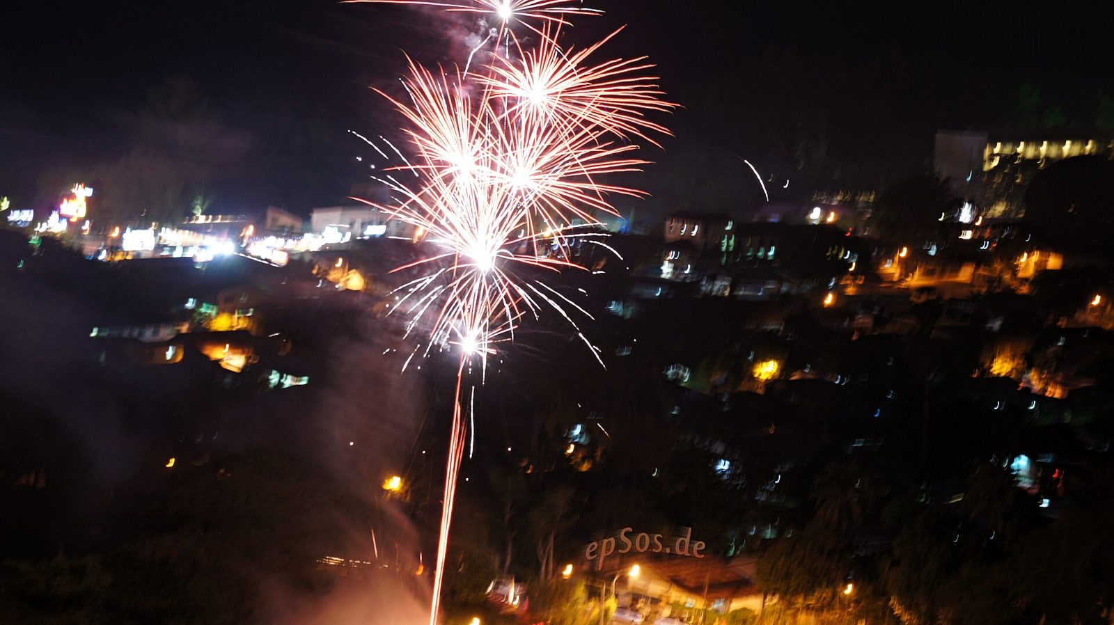 Fogos de artifício coloridos sobre a cidade à noite