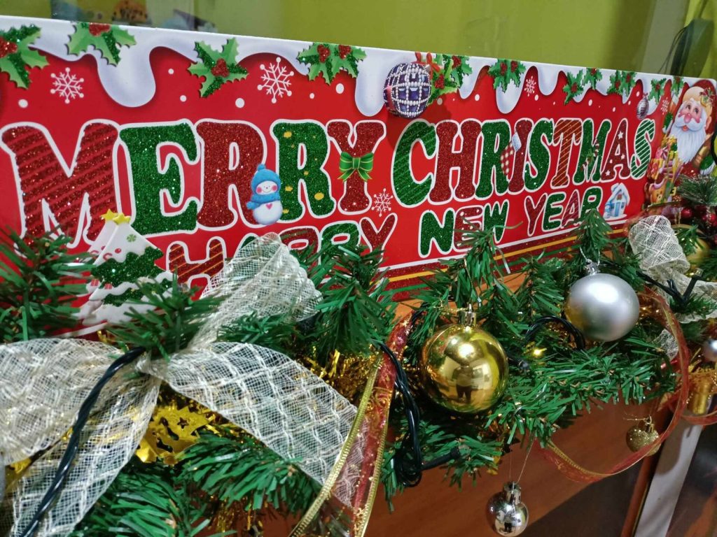 Decoração de Natal com faixa Merry Christmas, bolas e galhos