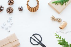 Materiais para enfeites de Natal: papel, barbante, tesoura e pinhas