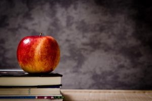 Maçã sobre livros na mesa, ideia de lembrancinha para professor