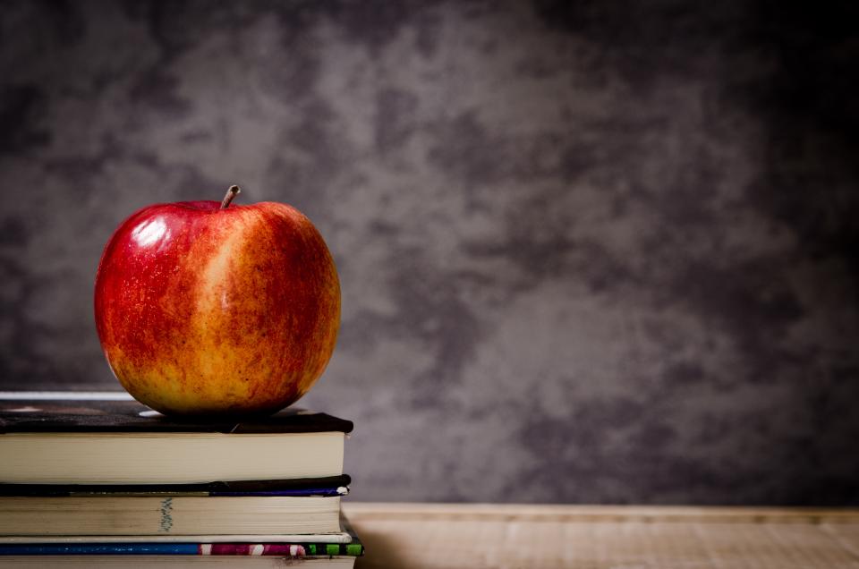 Maçã sobre livros na mesa, ideia de lembrancinha para professor