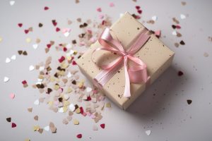Caixa de presente com laço rosa e confetes