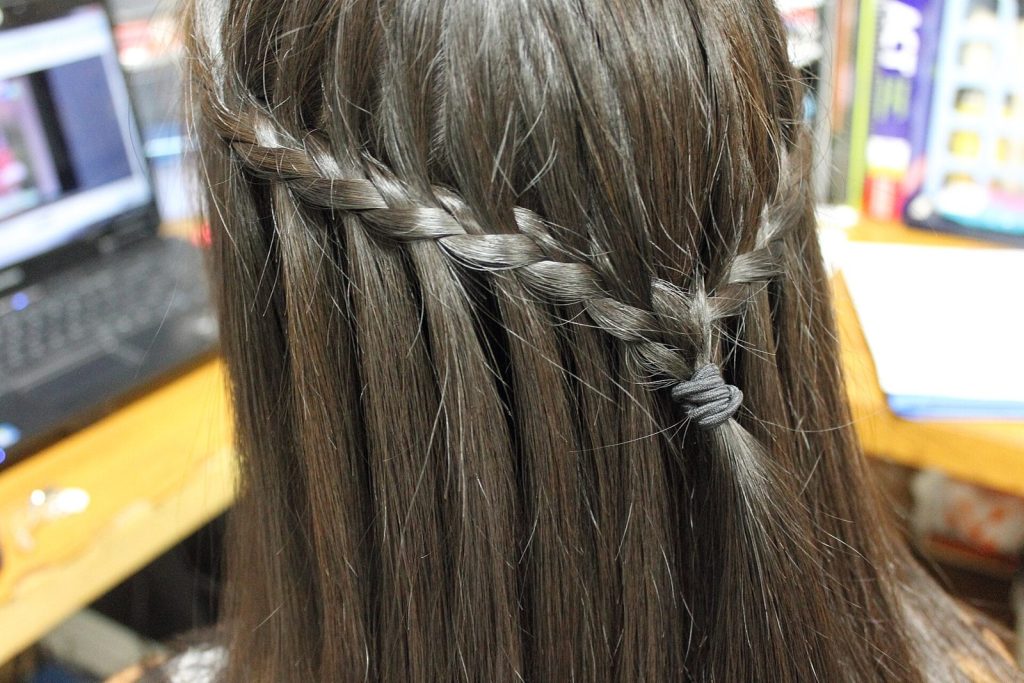Penteado com trança lateral presa atrás da cabeça