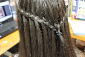 Penteado com trança lateral presa atrás da cabeça