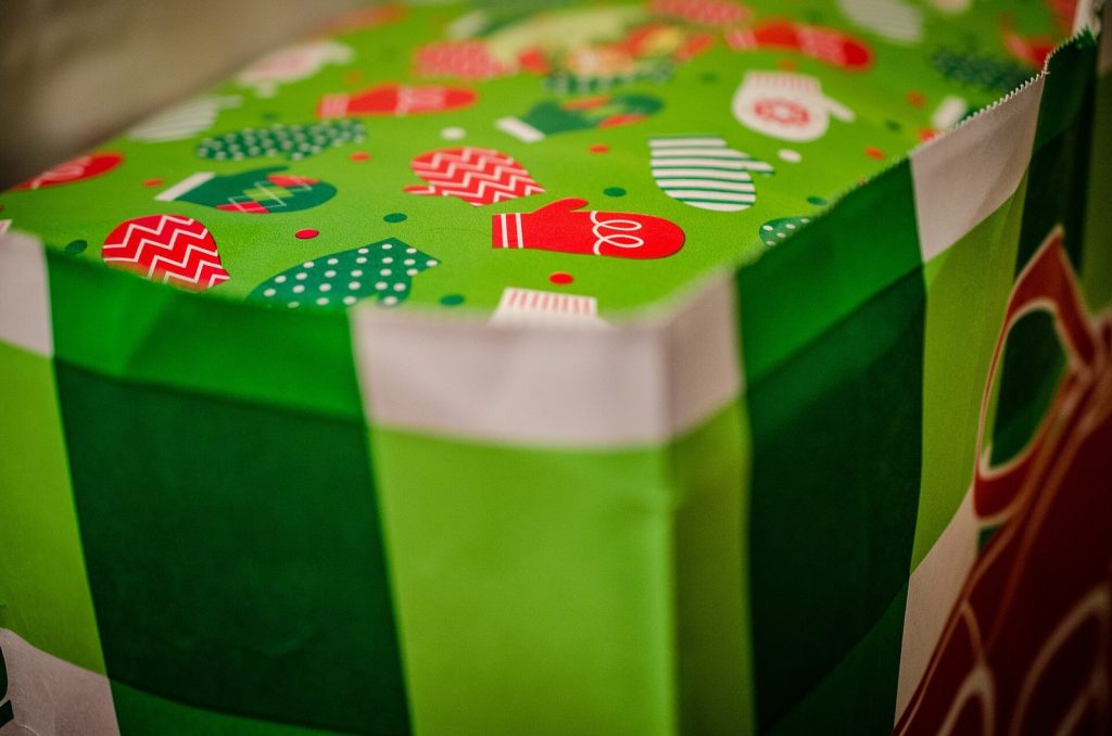 Caixa de presente embrulhada em papel verde com estampa de Natal